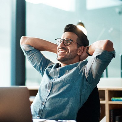 a man relaxing in a work office and leaning back in a chair