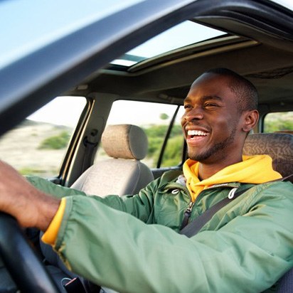 Man smiles while driving