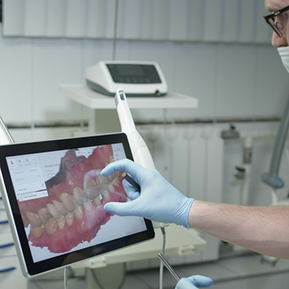 Dentist touching a screen with a close up digital model of a row of teeth