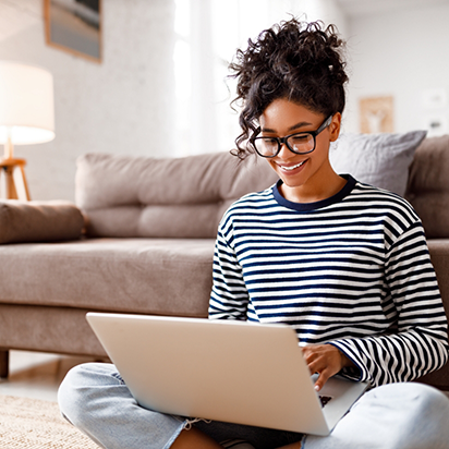 Young woman smiling while using her laptop