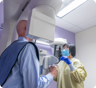 Dental patient receiving a cone beam C T scan of his mouth and jaw