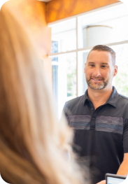 Man talking to dental office receptionist at front desk