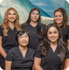 Five smiling Morgan Hill Dental Care team members in black scrubs