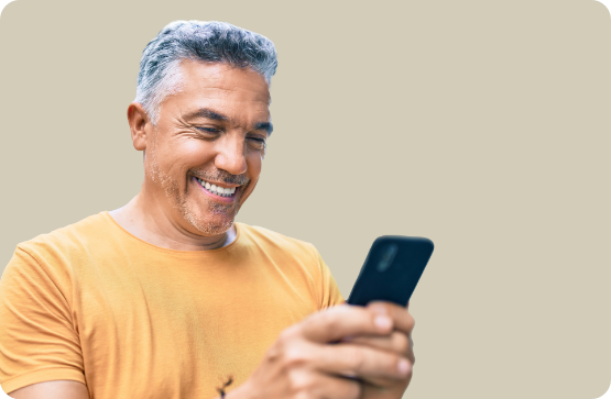 Man smiling while looking at his phone