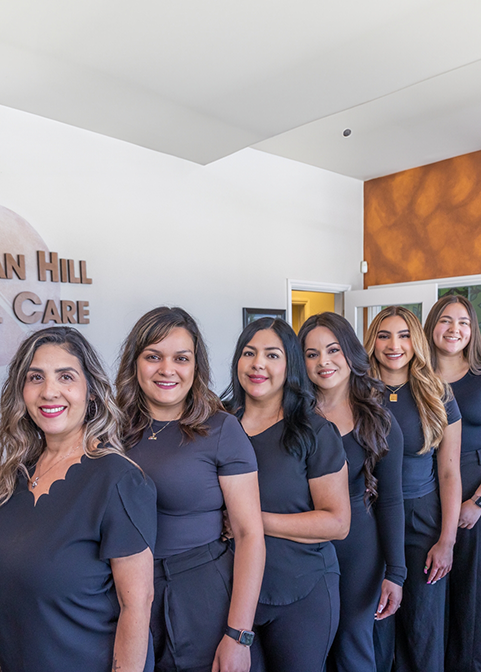 Six smiling Morgan Hill Dental Care team members standing in a line