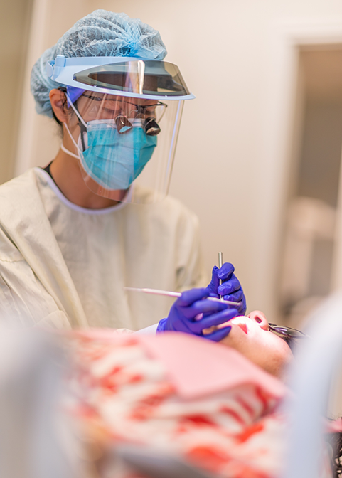 Dentist performing an oral surgery procedure on a patient