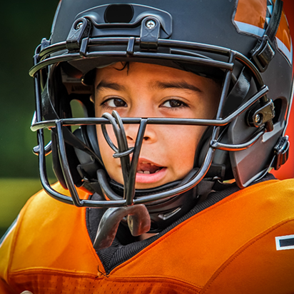 Child wearing a football uniform and helmet