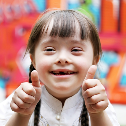 Young girl smiling and giving two thumbs up