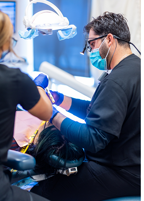 Dentist and assistant giving a patient a preventive dentistry exam