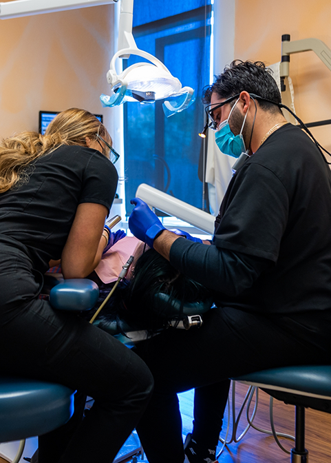 Dentist and assistant performing a restorative dentistry treatment on a patient