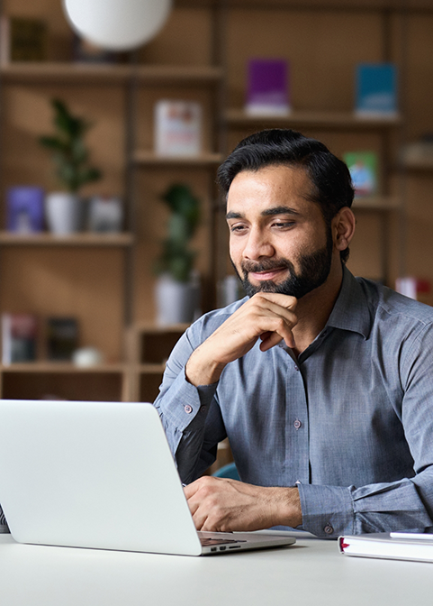 Man smiling while using his laptop